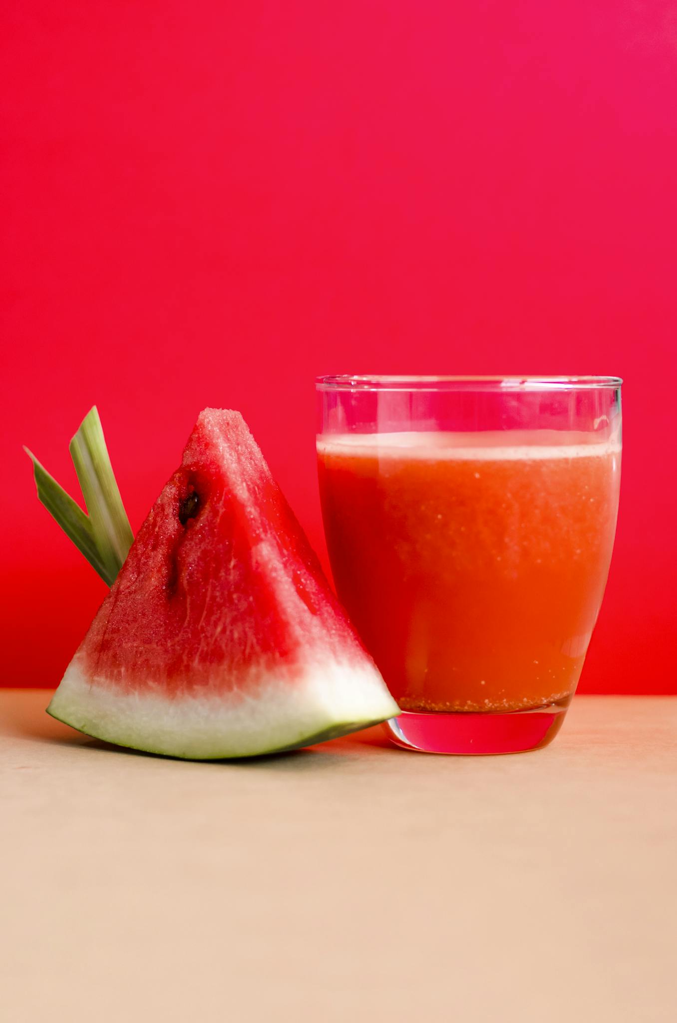 Watermelon Shake Filled Glass Cup Beside Sliced Watermelon Fruit on Brown Surface